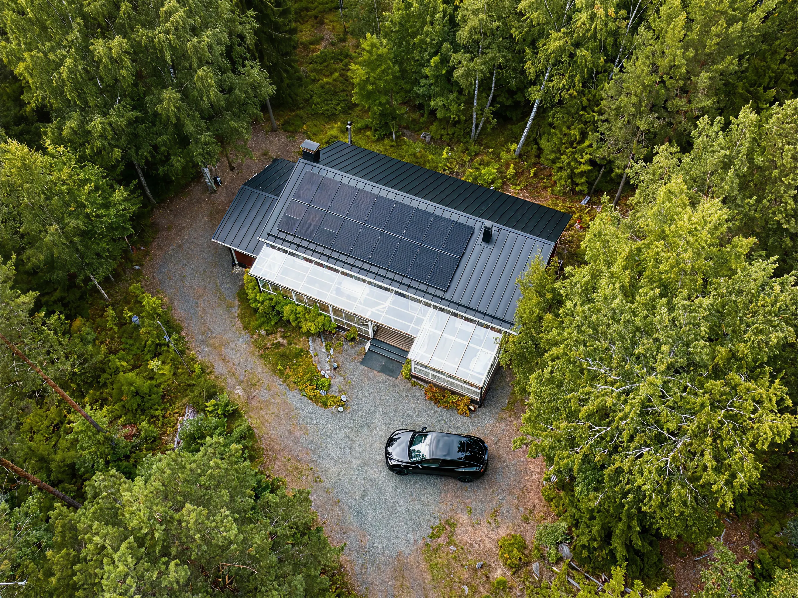 Modern home with solar panels surrounded by trees